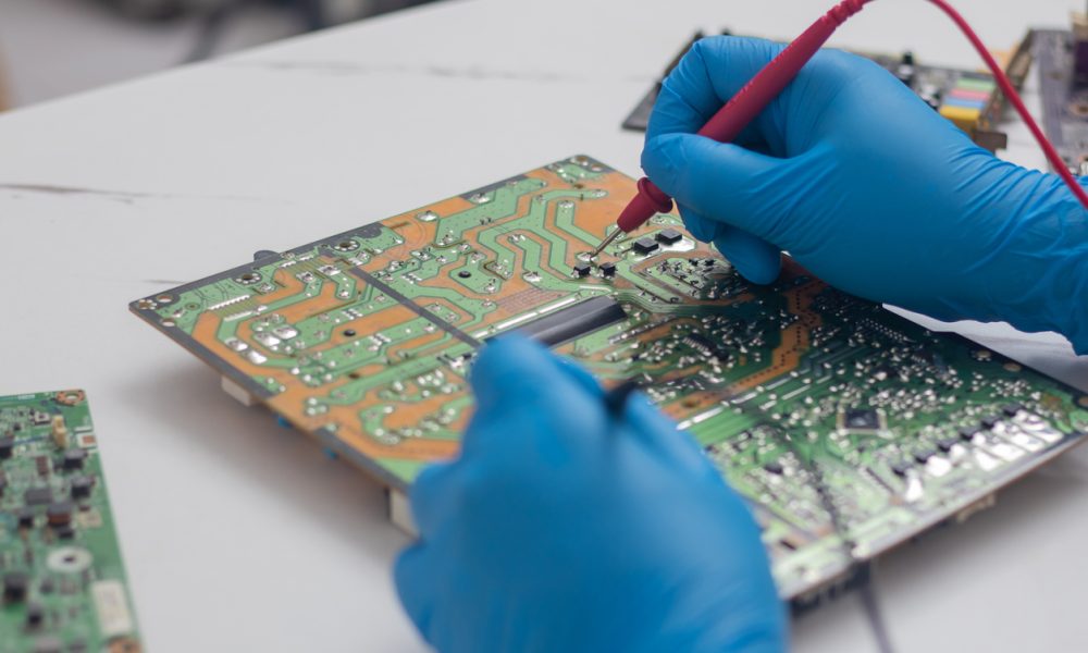 Ein Techniker arbeitet an einer Platine und einem Halbleiter.